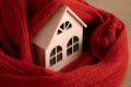maison miniature avec écharpe pour représenter le confort de l'isolation thermique